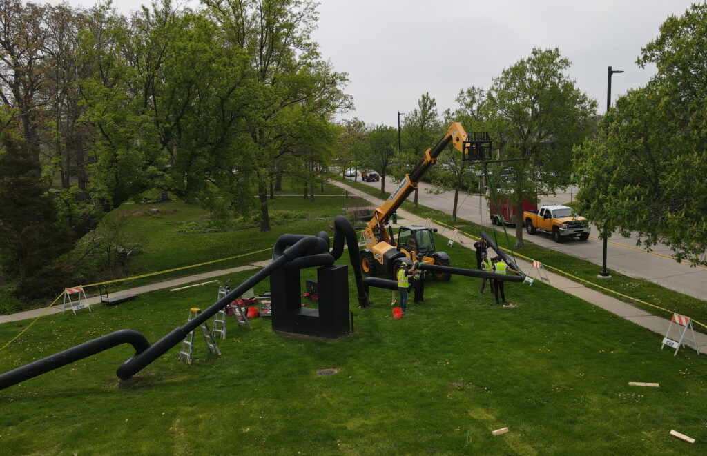 Workers remove the first piece from the Miss Nitro sculpture.